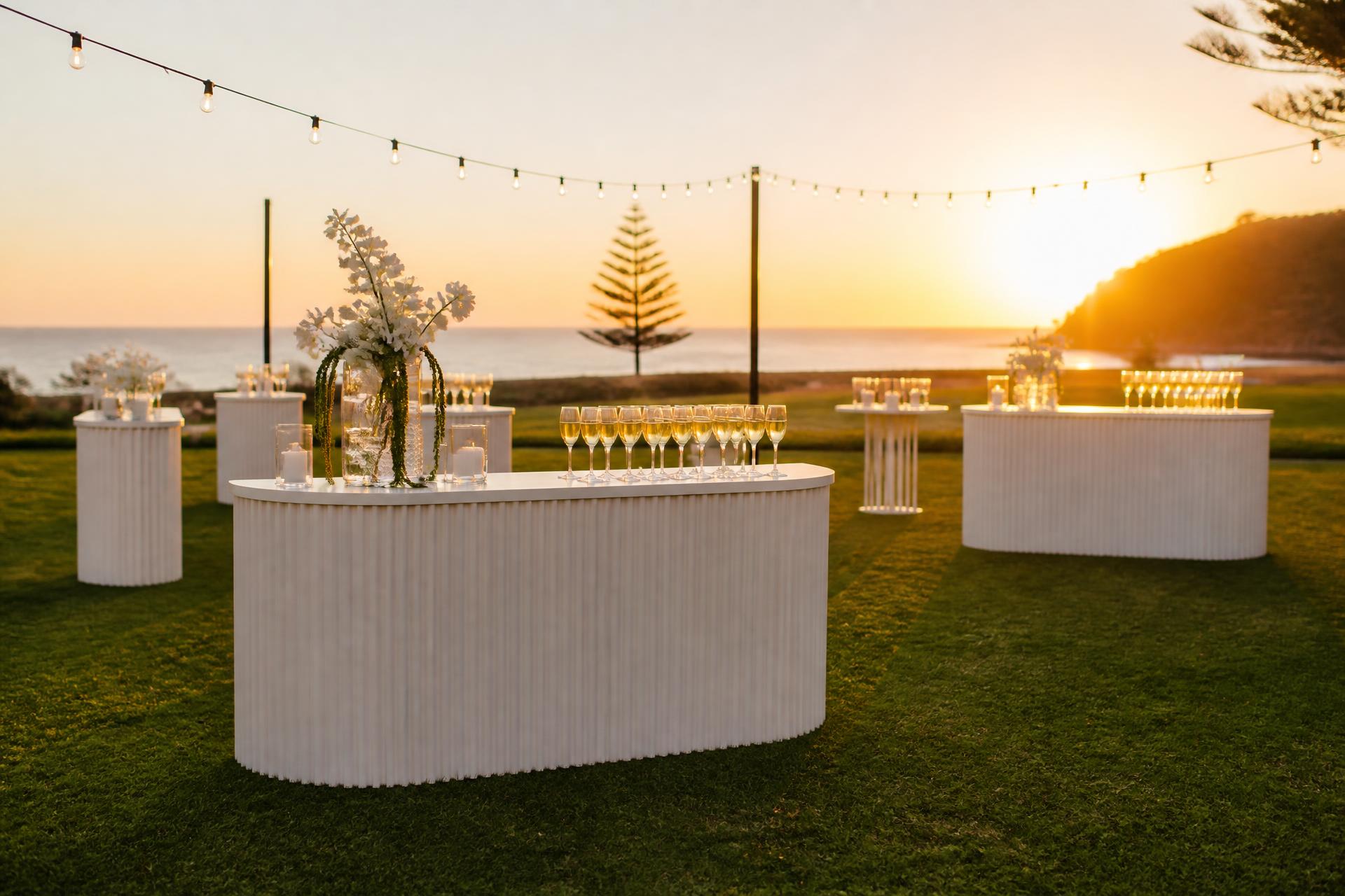 Stylish event setup with bar tables at golden hour